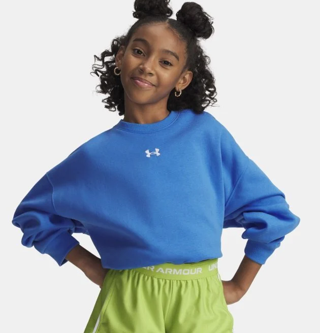 A young girl poses confidently in a bright blue Under Armour sweatshirt paired with lime green Under Armour shorts.